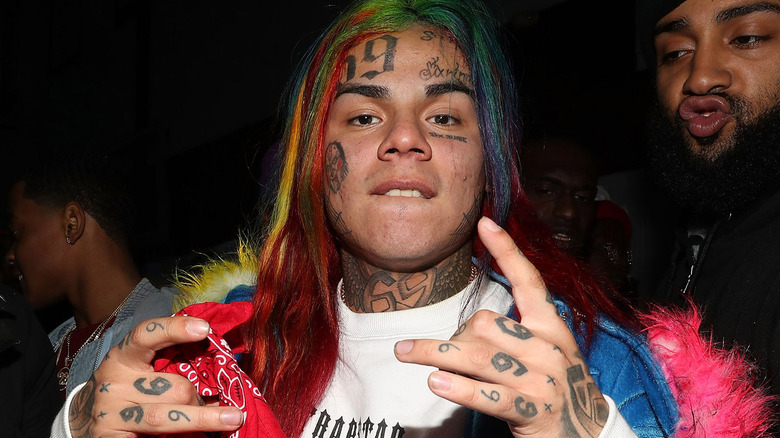 Tekashi 6ix9ine posing holding red bandana