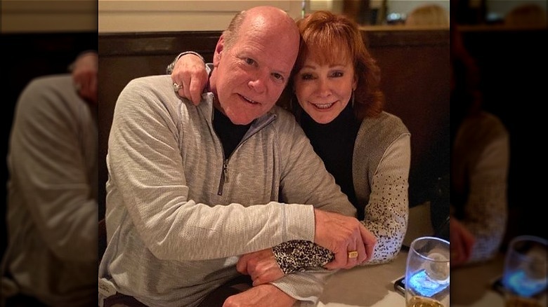 Rex Linn and Reba McEntire embracing