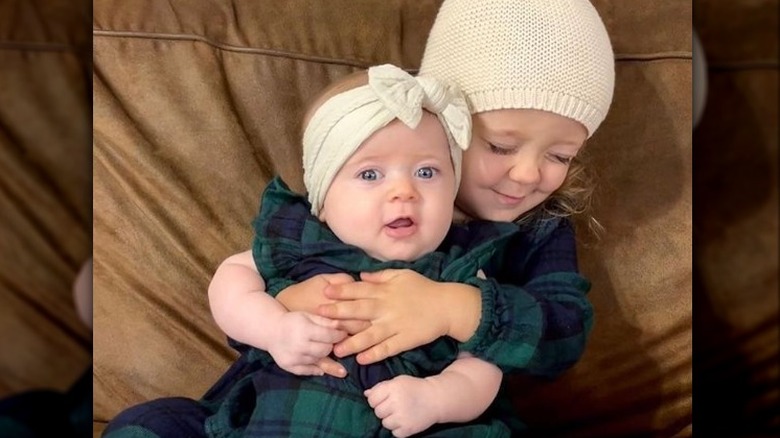 Ivy and Fern Seewald on brown couch