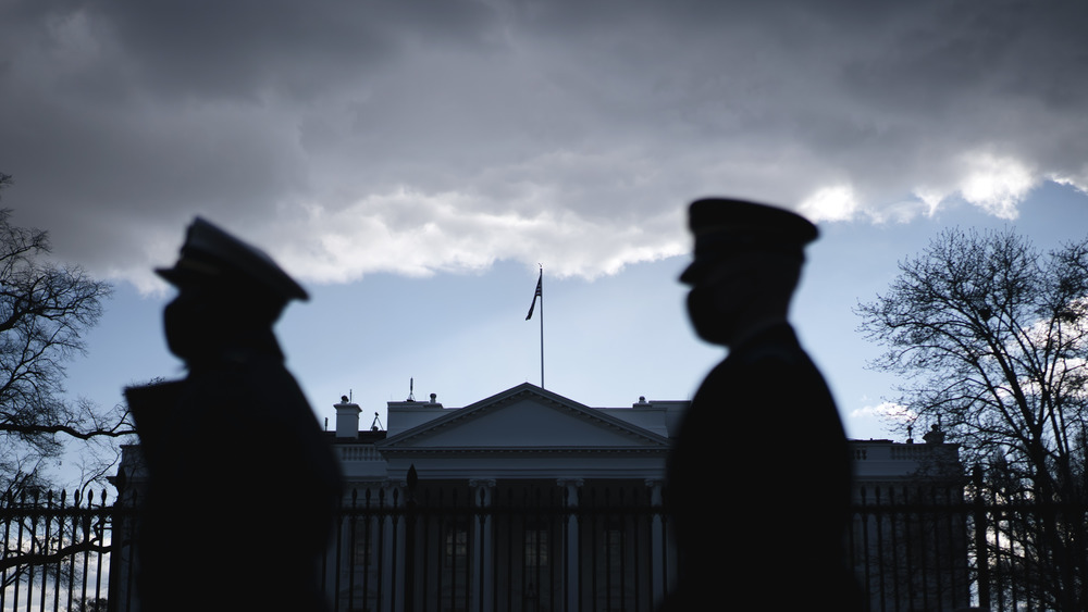 Security guards in silhouette in front of The White House