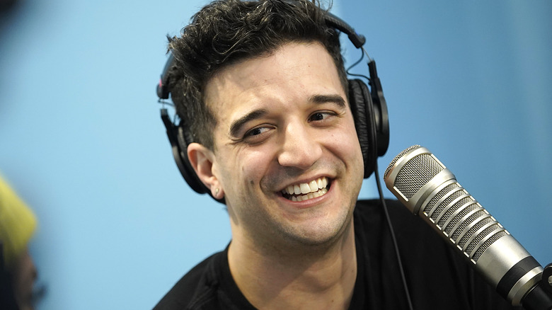 Mark Ballas smiling, wearing headphones 