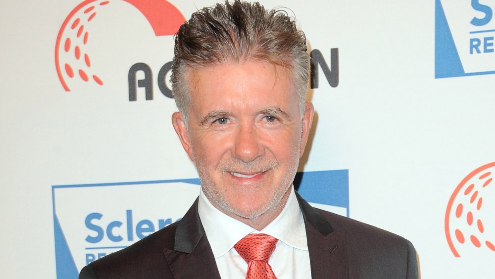 Alan Thicke grinning in a suit and red tie