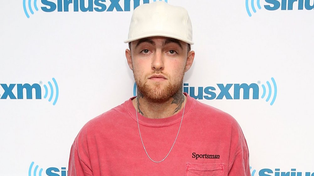 Mac Miller in a pink tee and white baseball cap