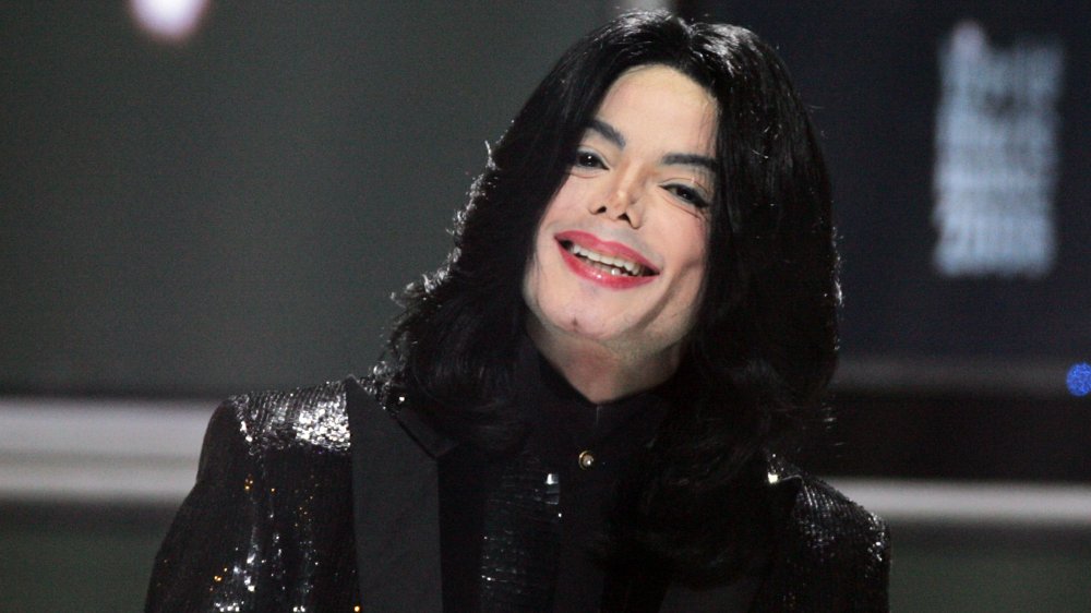 Michael Jackson in a black sequinned suit, smiling