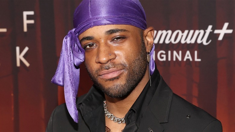 Khylin Rhambo purple do-rag red background, soft smile