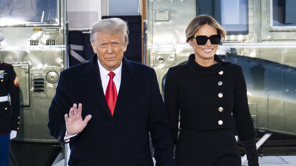 Donald Trump waving while Melania Trump smiles