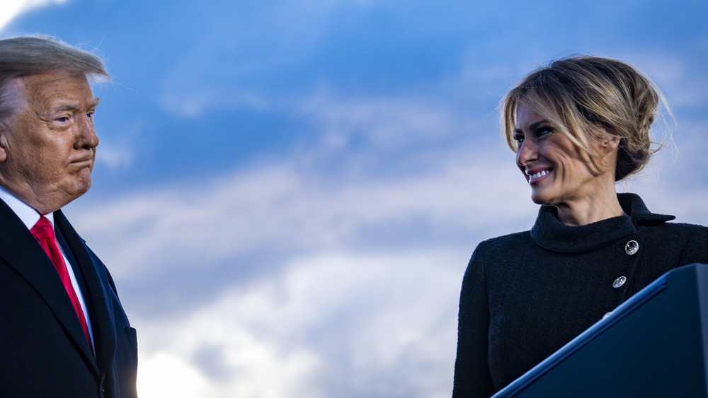 Melania Trump smiling while Donald Trump frowns