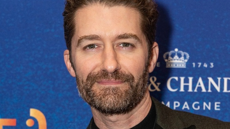 Closeup of Matthew Morrison blue background beard