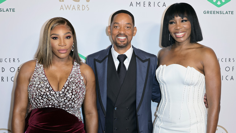 Will Smith poses between Serena and Venus Williams