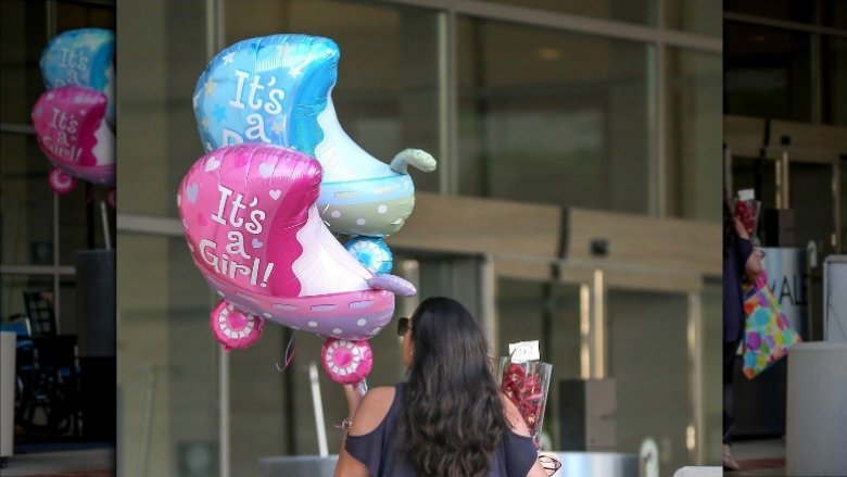 A woman arrives with balloons believed to be for Beyonce's twins