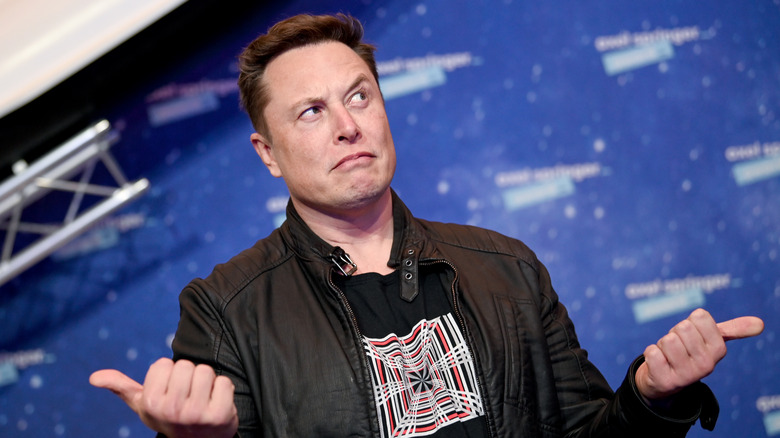 Elon Musk holding thumbs up