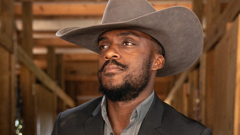 Ryan Black sitting in the stables with a cowboy hat on