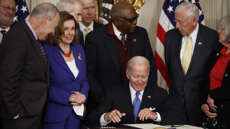 President Biden and House Speaker Nancy Pelosi appear at a signing