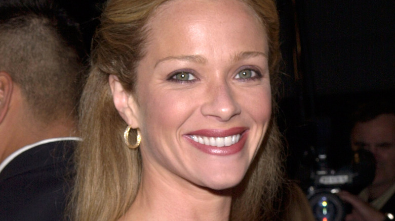 Lauren Holly smiles as she attends a movie premiere wearing hoop earrings