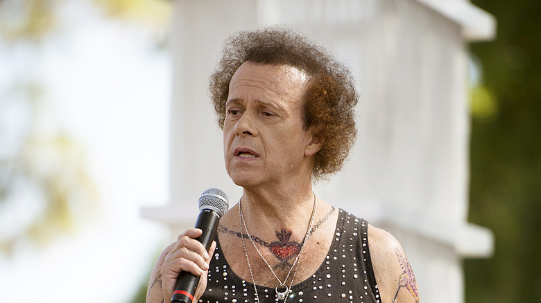 Richard Simmons holding a mic