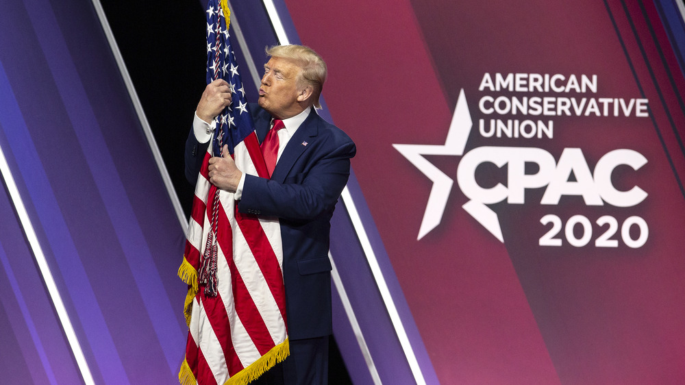 Donald Trump hugs and kisses the American flag during the Conservative Political Action Conference (CPAC) in National Harbor, Maryland, U.S., on Saturday, Feb. 29, 2020