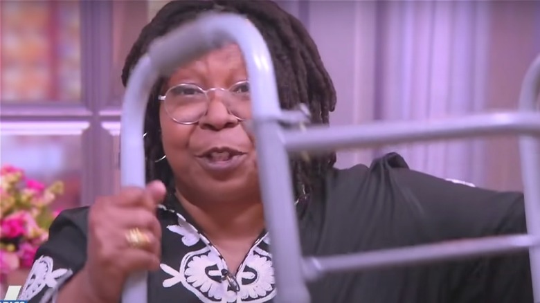 Whoopi Goldberg holding metal walker