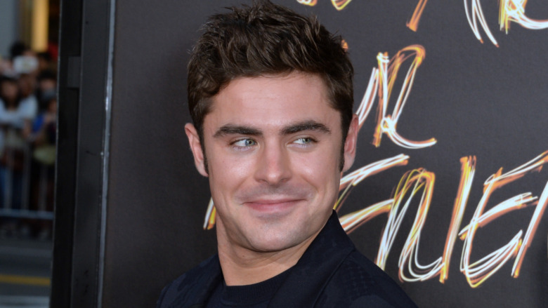 Zac Efron smirking at an event