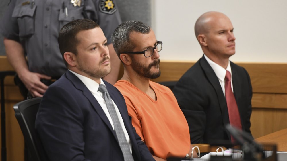 Chris Watts in an orange jumpsuit, sitting with his lawyers at his 2018 trial