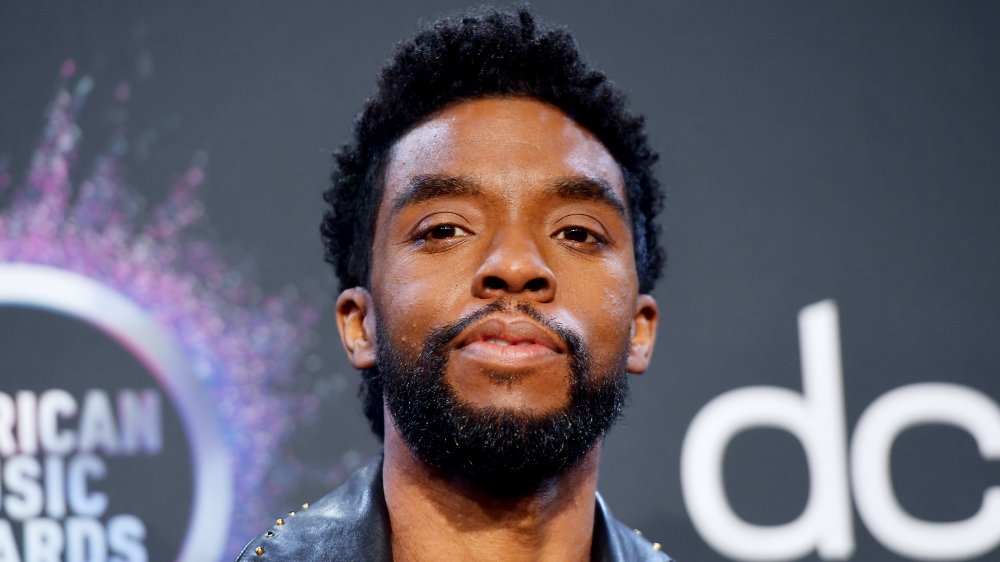 Chadwick Boseman in a black leather jacket, posing at the AMAs with a neutral expression