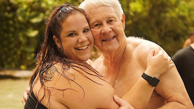 Whitney Thore and Glenn Thore hugging while swimming