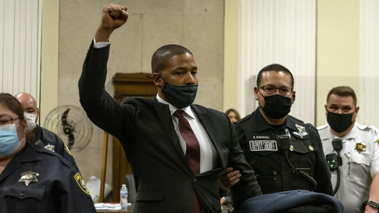 Jussie Smollett raising a fist while being escorted out of the courtroom