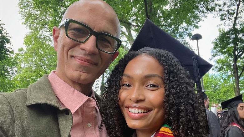 Yara Shahidi smiling with a graduation cap on, with her father, Afshin Shahidi