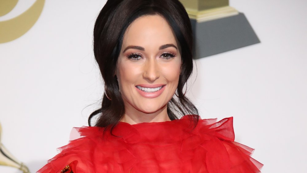 Kacey Musgraves in a red dress and hair pulled back