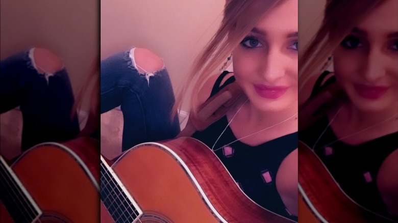 Moriah Plath, selfie while holding her guitar 