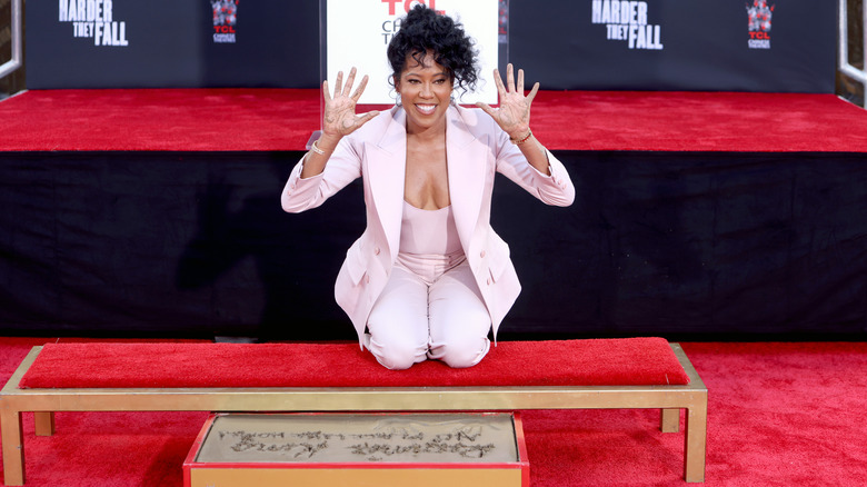 Regina King imprinting hands in cement