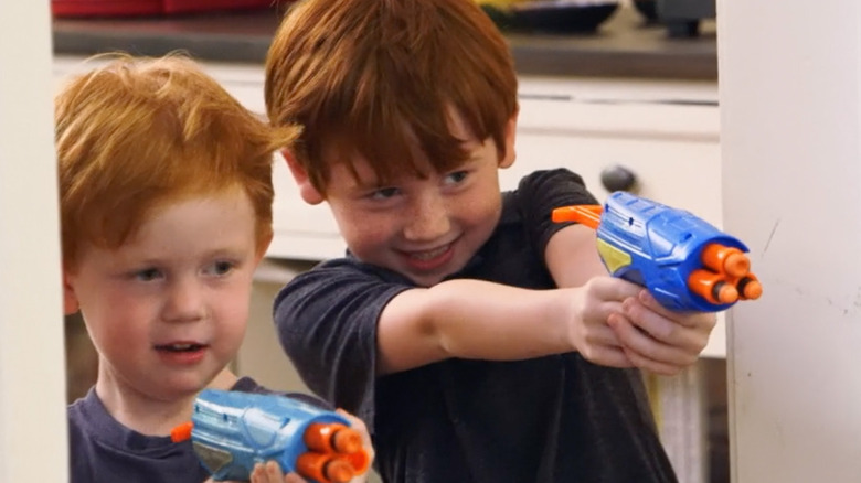 Two redheaded boys shooting water pistols