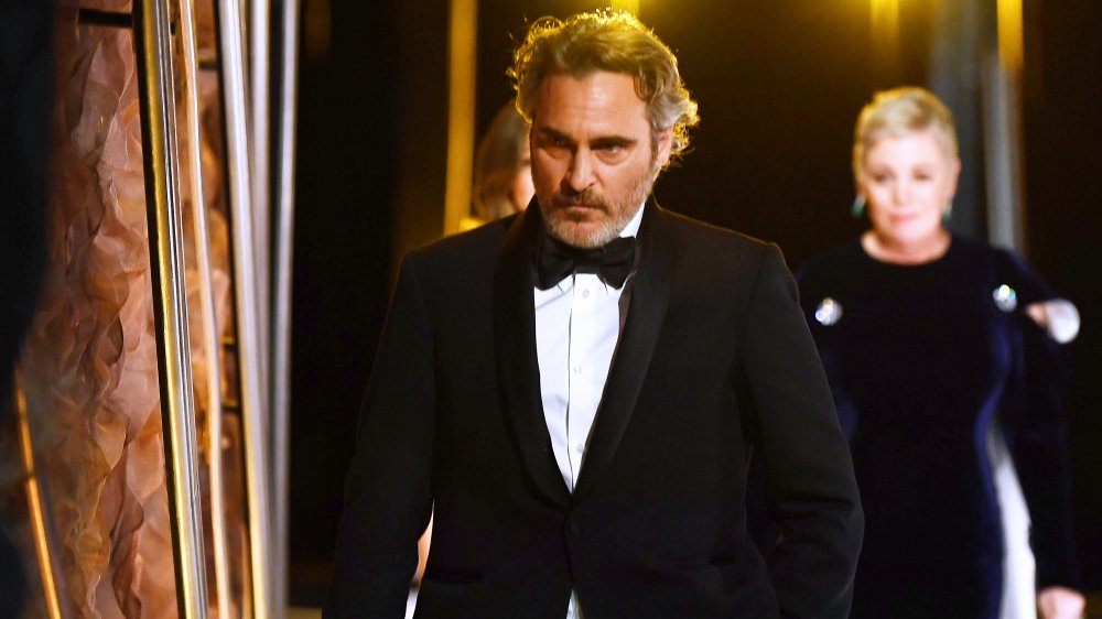 Joaquin Phoenix walking backstage at the Academy Awards