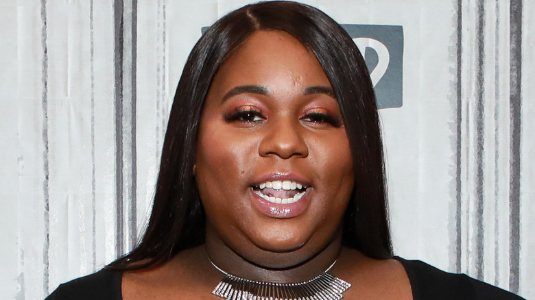 Alex Newell smiling at event