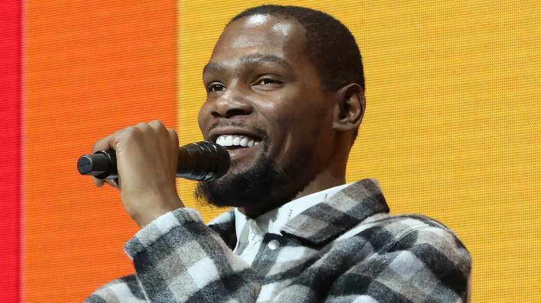 Kevin Durant holding a microphone, speaking