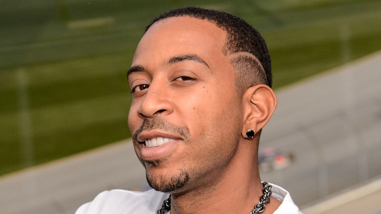 Ludacris smiling at a race track