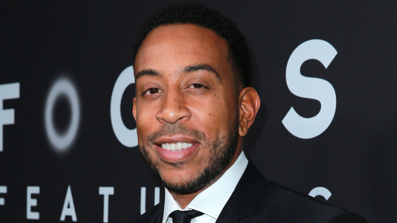 Ludacris smiling, wearing a suit