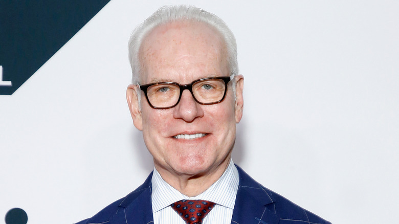 Tim Gunn smiling and wearing glasses