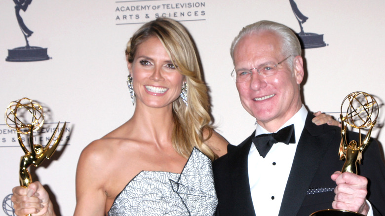 Heidi Klum and Tim Gunn smiling and holding Emmy Awards