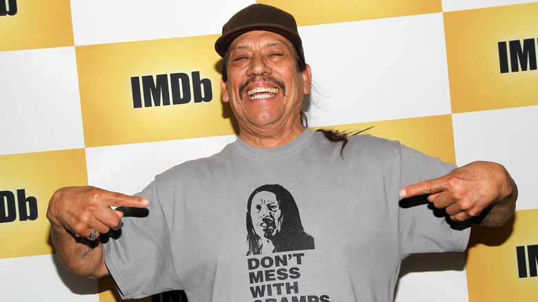 Danny Trejo smiling and pointing at t-shirt