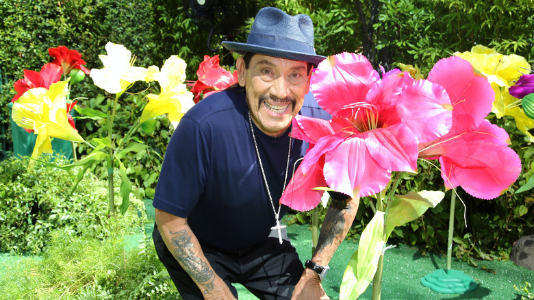 Danny Trejo smiling by flowers