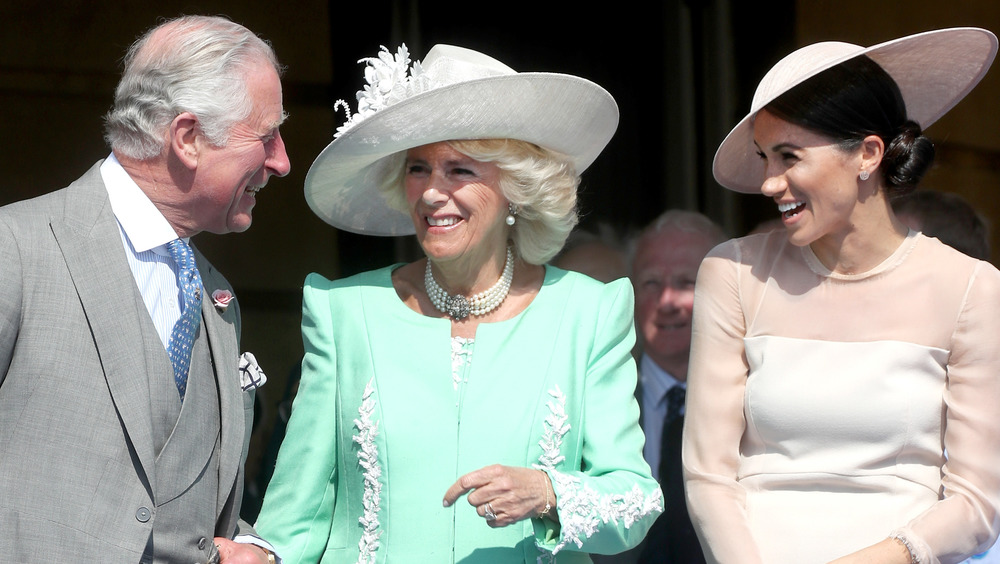 Prince Charles, Camilla, Duchess of Cornwall, and Meghan Markle laughing together 