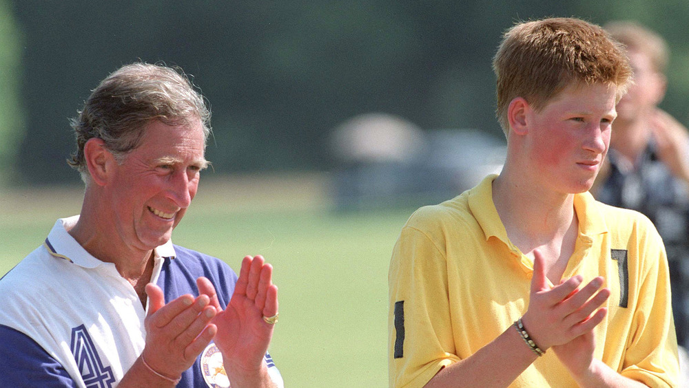 Prince Charles and a young Prince Harry applauding 