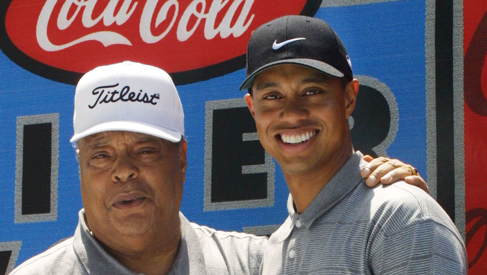 Tiger Woods and his dad Earl Woods pose during a golf foundation event in 2001