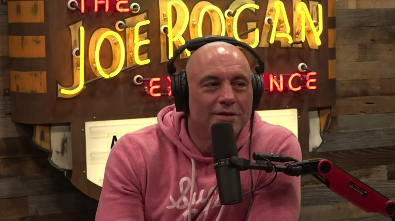 Joe Rogan seated behind mic