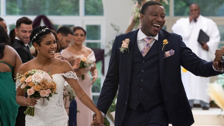 Jarrette and Iyanna at their wedding, smiling and walking down aisle