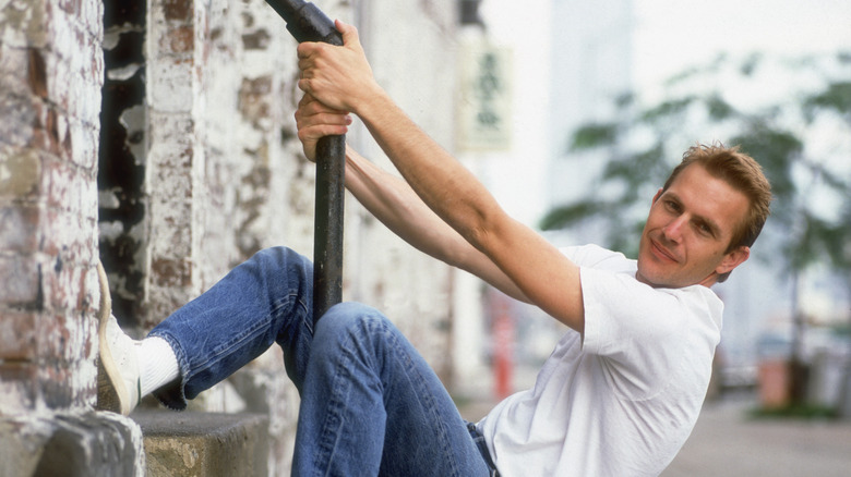 Young Kevin Costner hanging off pole