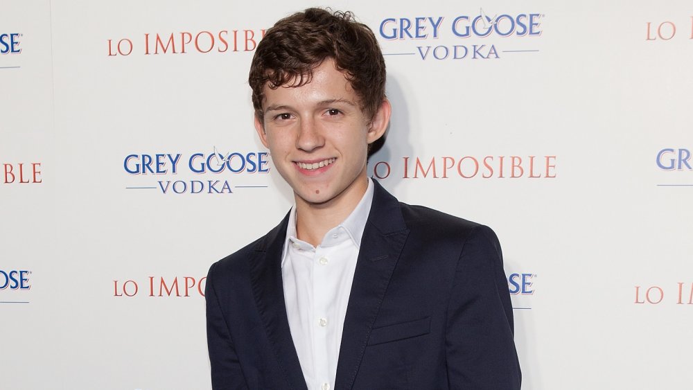 A teenage Tom Holland smiling at The Impossible premiere