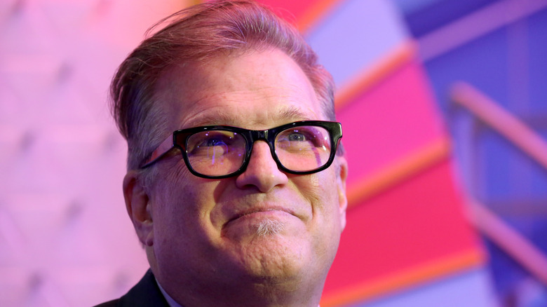 Drew Carey posing at an event.