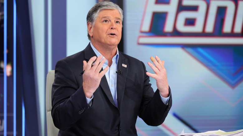 Sean Hannity gestures animatedly while filming his TV show.