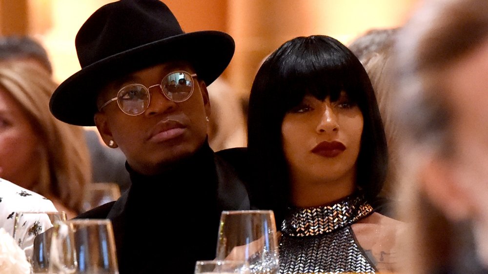 Ne-Yo in hat and glasses sitting next to Crystal Renay